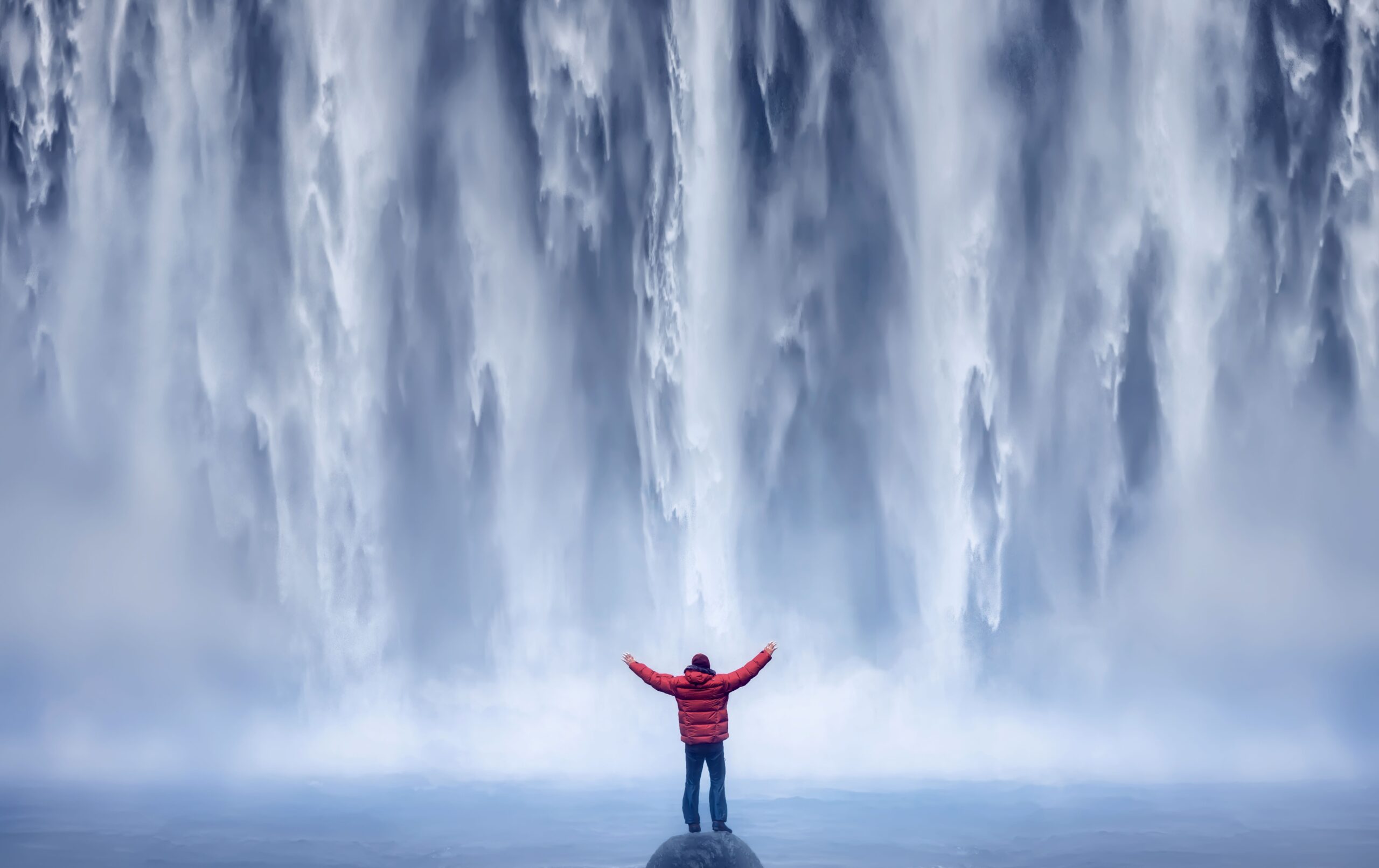 Ein Wasserfall in Island mit einem Menschen.
